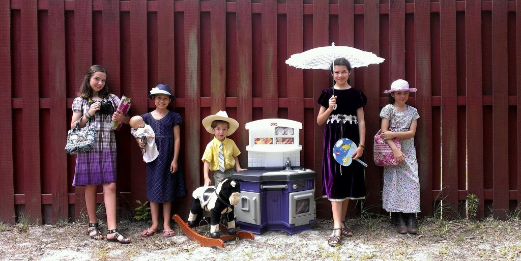Portrait of my five children standing against a fence wearing their favorite outfits and holding their favorite things.